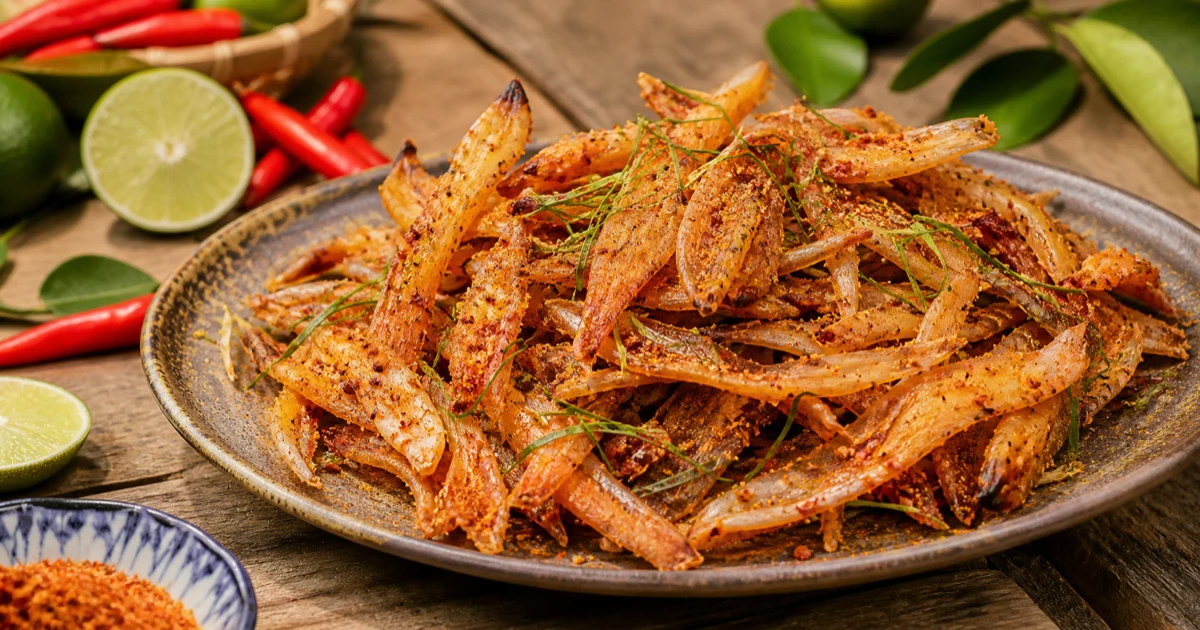 Đĩa mực một nắng kho gừng nước sánh vàng nâu, thịt mực cắt khoanh dày dai, rắc gừng sợi thơm, ớt đỏ tươi, hành lá xanh, chén cơm trắng bên cạnh