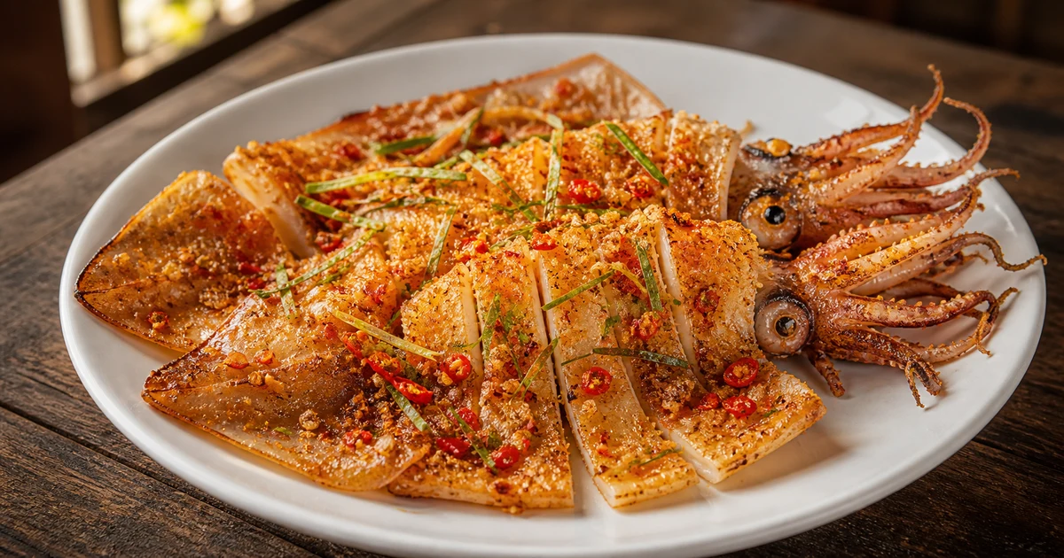 Mực một nắng gỏi xoài xanh — sợi mực dai vàng, xoài bào sợi, rau thơm và đậu phộng rang